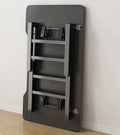 Foldable gaming table folded flat against a wall